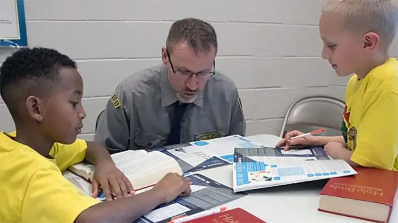 A Cadet counsellor working through a lesson with two boys at Bethel.